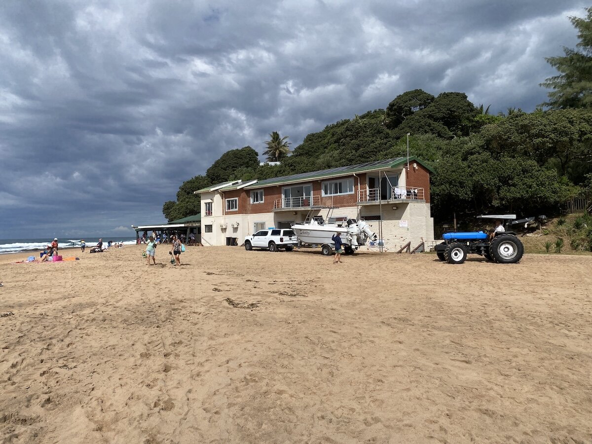Beach tractor and ski-boats outside Zinkwazi ski-boat club under dramatic stormy skies