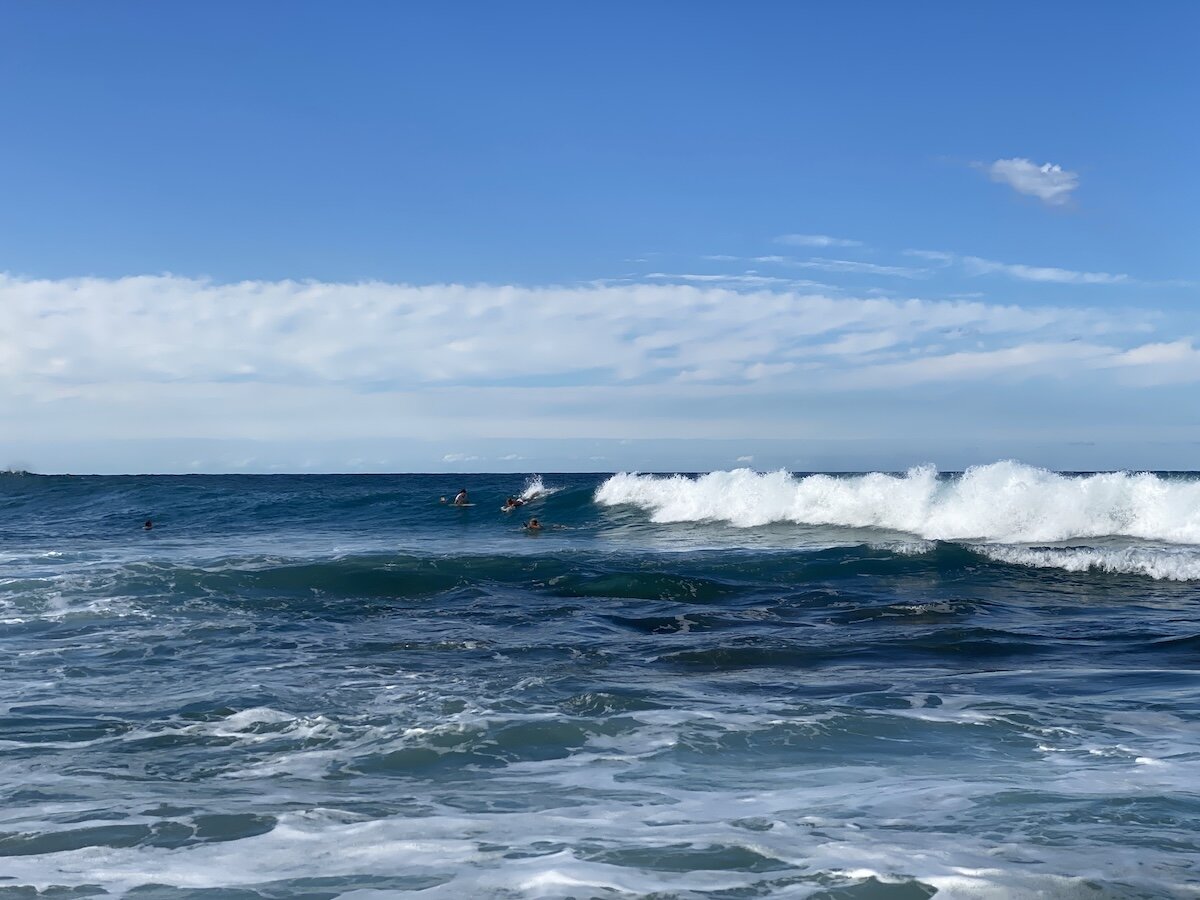 Surfers in the lineup catching a breaking wave at Zinkwazi main beach in winter
