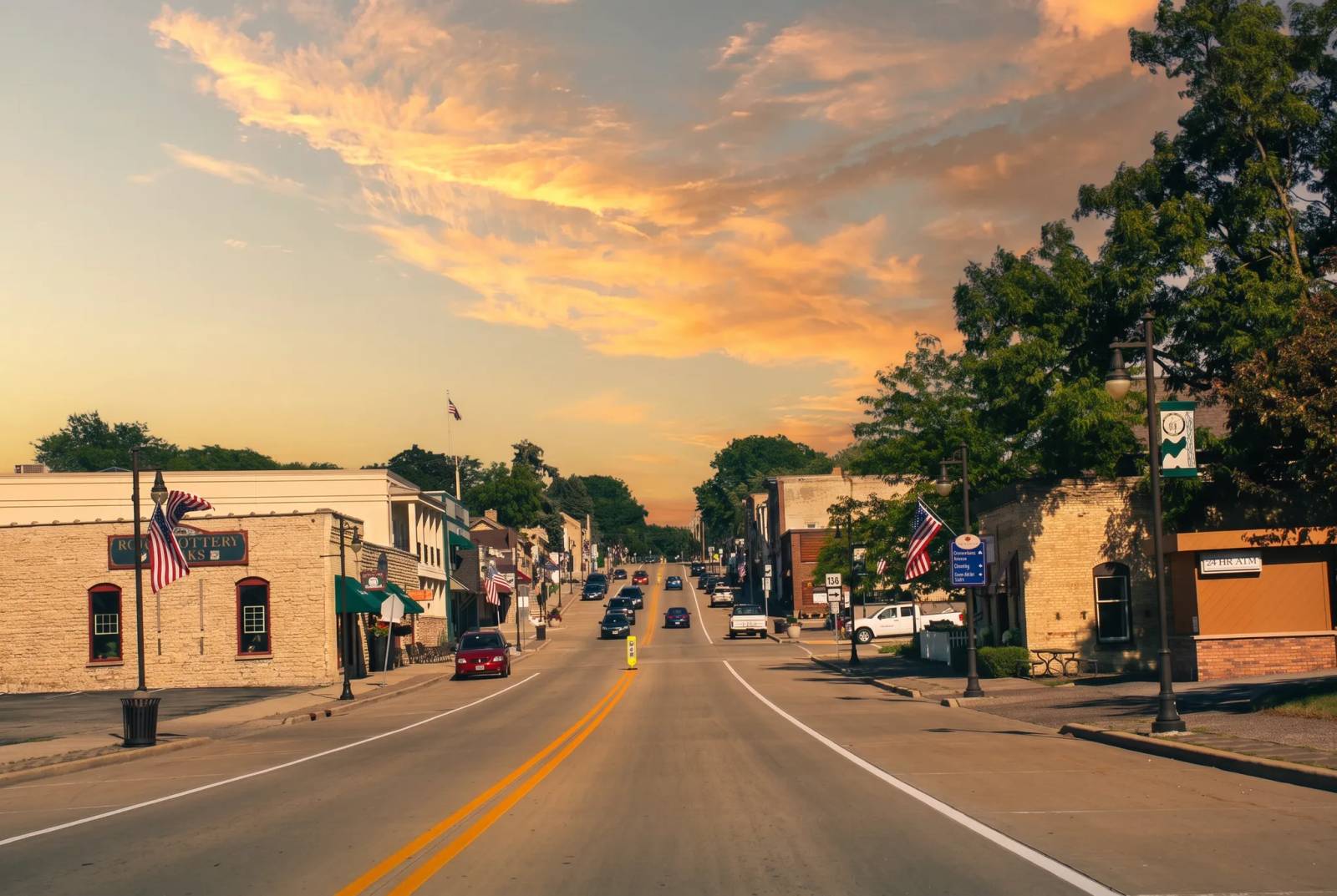 Downtown Cambridge, Wisconsin along US 12 at golden hour, with brick storefronts and flags.