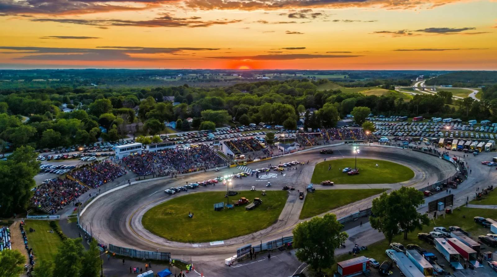 Aerial view of a packed race track and stands at sunset in Slinger.