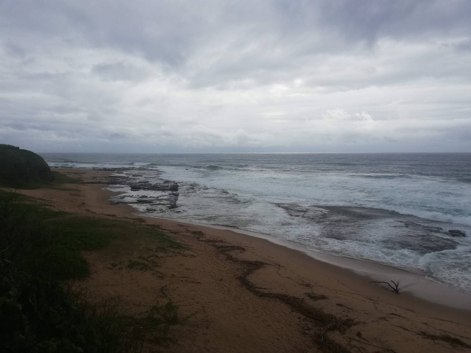 Overcast sky above the ocean and rocky shoreline in Sheffield Beach.